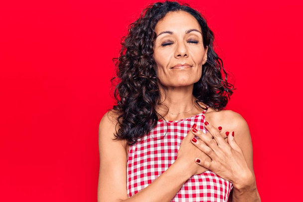 Middle age beautiful woman wearing casual sleeveless t shirt smiling with hands on chest, eyes closed with grateful gesture on face. health concept.  - Photo, Image