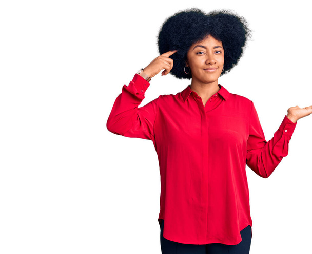 Jong Afrikaans Amerikaans meisje draagt casual kleding verward en geïrriteerd met open palm tonen kopieerruimte en wijzende vinger naar het voorhoofd. Denk er eens over na..  - Foto, afbeelding