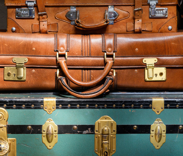 Montón de equipaje antiguo vintage de cerca con un colorido tronco azul y dos maletas de cuero en un concepto de viaje
 - Foto, Imagen