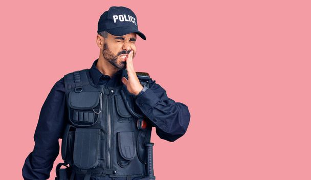 Junge hispanische Mann in Polizeiuniform berühren Mund mit der Hand mit schmerzhaftem Gesichtsausdruck wegen Zahnschmerzen oder Zahnerkrankungen an den Zähnen. Zahnarzt  - Foto, Bild