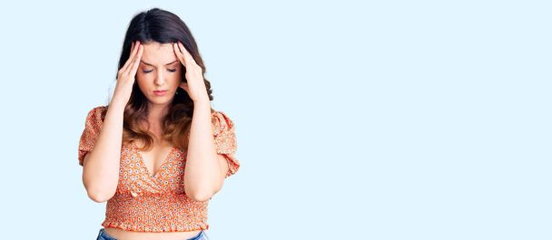 Beautiful young brunette woman wearing casual clothes with hand on head for pain in head because stress. suffering migraine.  - Fotoğraf, Görsel
