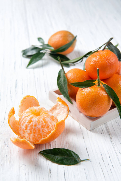 Mandarim ou clementina com folhas na mesa de madeira, frutas de inverno
 - Foto, Imagem