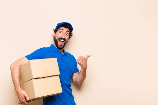 young bearded delivery man with a box - Foto, afbeelding