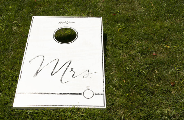 Egy fehér búzalyuk játék egy zöld gyepen Mrs. Fekete, mint egy esküvői ajándék. - Fotó, kép