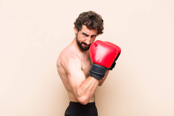 young cool bearded man with boxing gloves and fighting. fitness  - Foto, Imagem