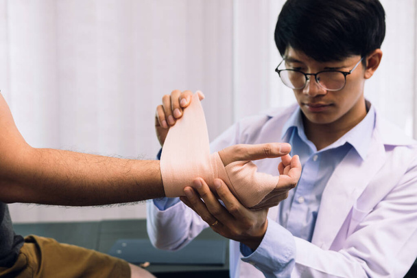Asiatische Physiotherapeuten untersuchen Ergebnisse von Handgelenks-Operationen von Patienten. - Foto, Bild