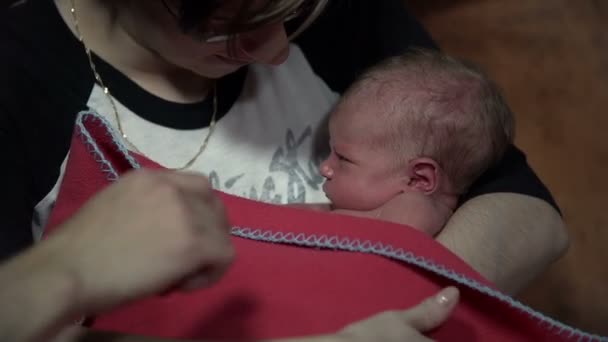 Madre cubriendo al bebé con manta roja y tratándolo amorosamente
 - Imágenes, Vídeo