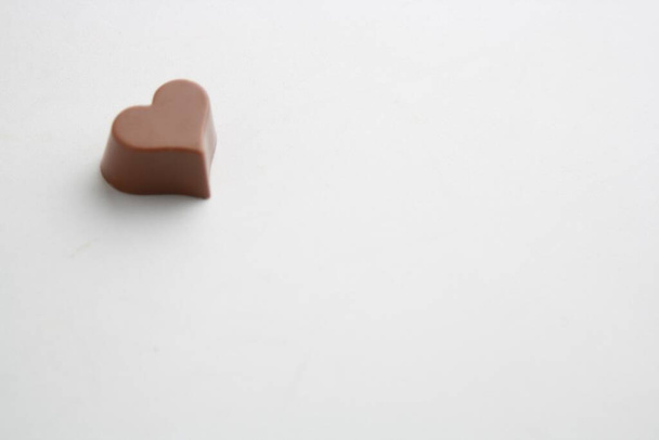 A chocolate candy with a heart shape isolated on a white background - 写真・画像