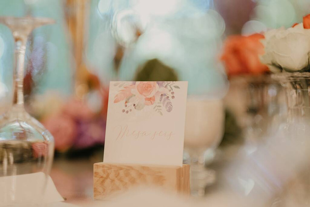 A selective focus shot of a card in the middle of wine glasses - Фото, изображение