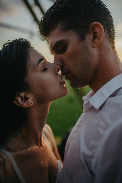Verliebtes Paar küsst und umarmt sich unter Regentropfen. Porträt. - Foto, Bild