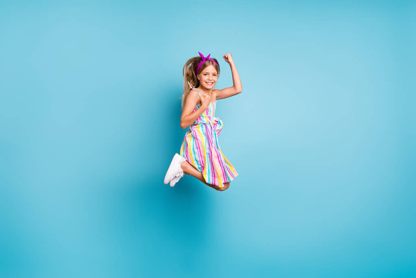 Full length body size view of her she nice attractive lovely pretty glad cheerful cheery girl jumping rejoicing good news attainment isolated on bright vivid shine vibrant blue color background - 写真・画像