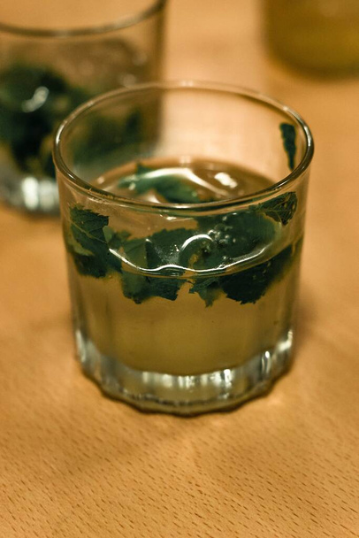 A vertical closeup shot of a green mint cocktail in a glass - 写真・画像