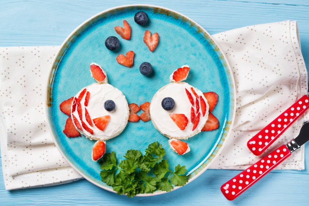Vicces pirítós alakú csók halak, szendvics krémsajttal és bogyókkal, élelmiszer gyerekeknek ötlet, felülnézet - Fotó, kép