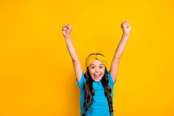 Portrait of ecstatic positive girl kid enjoy rejoice lottery lucky win raise fists scream yeah wear trendy clothes isolated over shine color background - Foto, Imagem