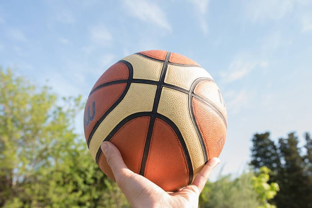 A man holding a basketball ball in one hand - Foto, afbeelding