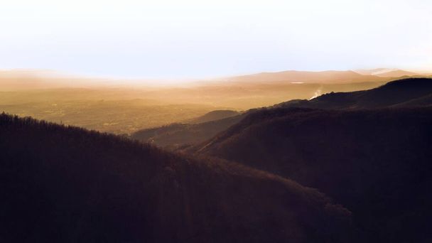 A landscape shot of beautiful hills covered in forests during the sunset - Fotoğraf, Görsel