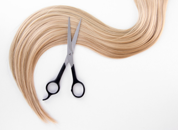 Long blond hair and scissors isolated on white - Fotó, kép