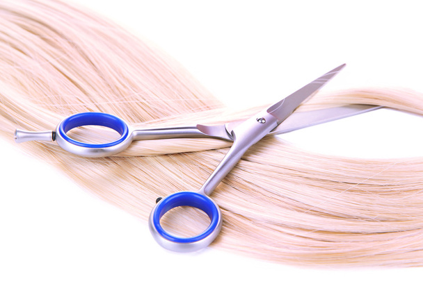 Long blond hair and scissors isolated on white - Photo, image