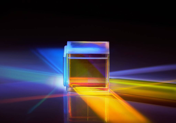 Un gros plan de cube carré réfléchissant dichroïque diffusant le faisceau de lumière en plusieurs couleurs - Photo, image