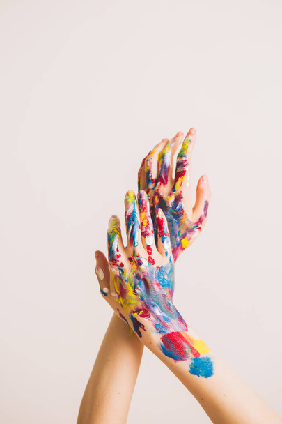 Womans artists arms in paints isolated on a white background. Colorful photography for art or womens blog - Фото, изображение
