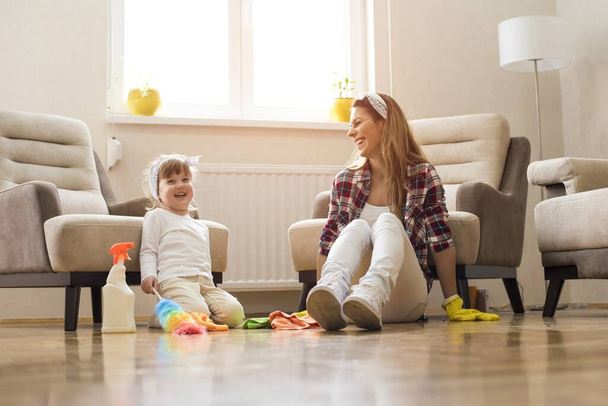 A picture of a brunette female with a kid doing a housework - Foto, Imagen