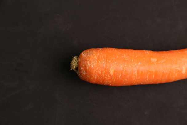 A closeup shot of a fresh carrot on black background - Foto, Imagen