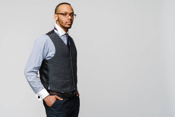 Uomo d'affari afro-americano che indossa occhiali ritratto su sfondo grigio - Foto, immagini