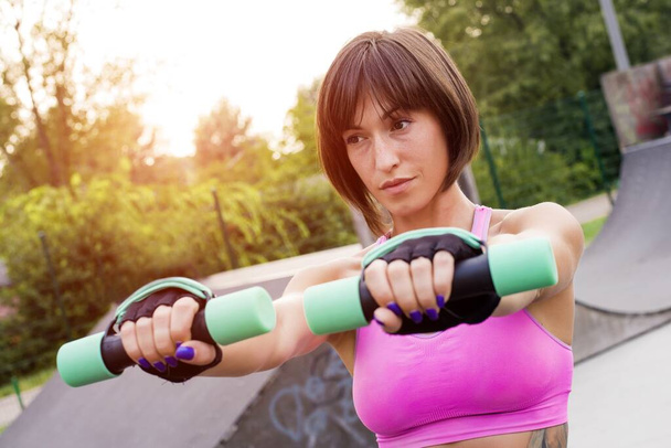 A shallow focus shot of a sporty female doing a workout in the park - 写真・画像