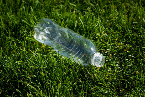 プラスチックボトルは森の中の地面の芝生の上に置かれています環境汚染環境問題プラスチックや地球環境汚染ゴミ廃棄物 - 写真・画像