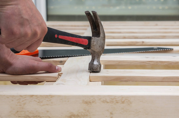 man maakt een houten bed met zijn eigen handen, met de hand gemaakt - Foto, afbeelding
