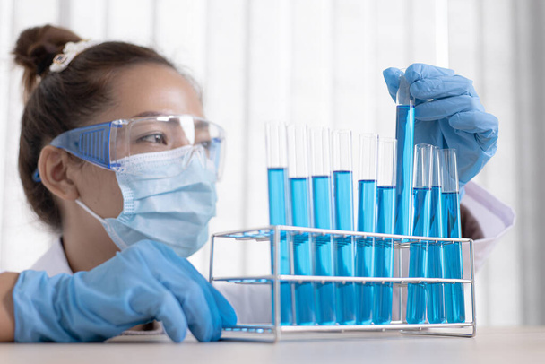 Los científicos están llevando tubos de ensayo químicos azules para prepararse para la determinación de la composición química y la masa biológica en un laboratorio científico, los científicos y la investigación en el laboratorio Concepto
. - Foto, Imagen