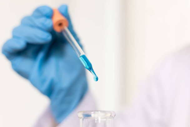 Scientists are carrying blue chemical test tubes to prepare for the determination of chemical composition and biological mass in a scientific laboratory, Scientists and research in the lab Concept. - Foto, Imagem