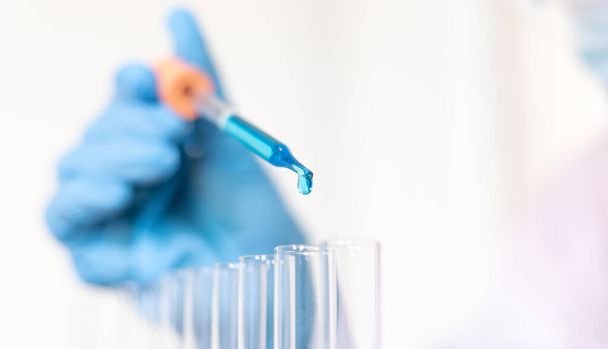 A tudósok kék kémiai kémcsöveket hordoznak, hogy felkészüljenek a kémiai összetétel és a biológiai tömeg meghatározására egy tudományos laboratóriumban, tudósok és kutatások a laborban Koncepció. - Fotó, kép