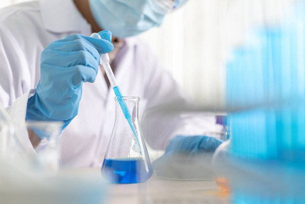 Les scientifiques portent des tubes à essai chimiques bleus pour se préparer à la détermination de la composition chimique et de la masse biologique dans un laboratoire scientifique, Les scientifiques et la recherche dans le laboratoire Concept. - Photo, image