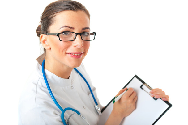 Female doctor writing on clipboard - Zdjęcie, obraz