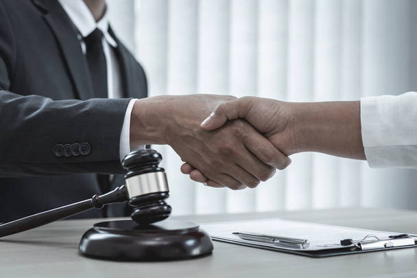 Адвокати або консультанти об'єднують зусилля з клієнтами, щоб привітати закінчення справи компанією, переговорами або концепцією вирішення судових спорів
. - Фото, зображення