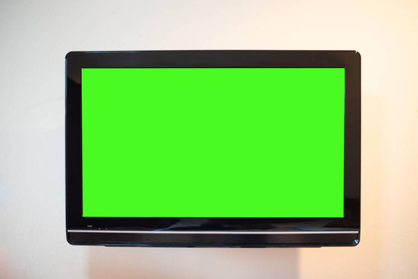 Monitor da vicino schermo verde sullo sfondo della parete. - Foto, immagini