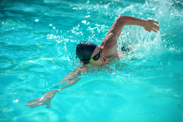 Man swimming on his side in the pool - Φωτογραφία, εικόνα