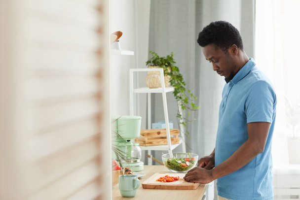 Ο άνθρωπος ετοιμάζει σαλάτα στο σπίτι - Φωτογραφία, εικόνα
