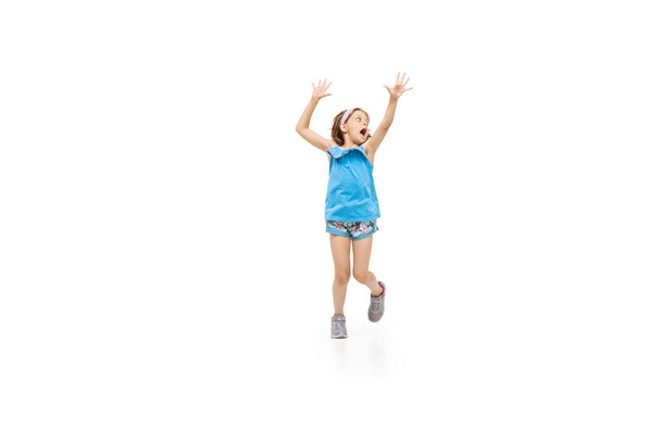 Happy little caucasian girl jumping and running isolated on white background - Fotoğraf, Görsel