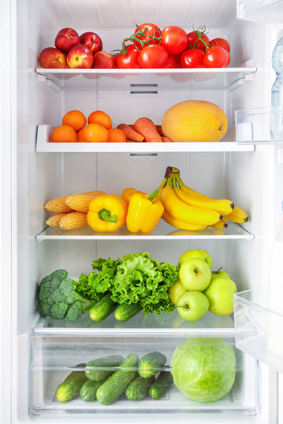 Открытый холодильник с овощами и фруктами - Фото, изображение