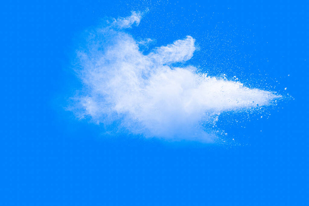Έκρηξη λευκής σκόνης σε μπλε φόντο. Λευκά σωματίδια σκόνης πιτσιλίζουν.Color Holi Φεστιβάλ. - Φωτογραφία, εικόνα
