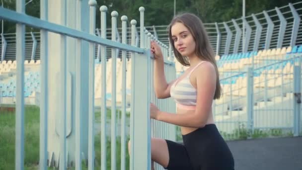 Femme caucasienne sportive avec de longs cheveux blonds se reposant après l'exercice en plein air pendant la journée - Séquence, vidéo