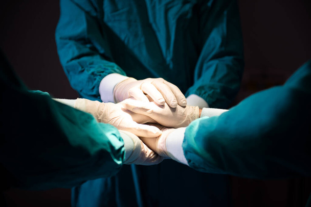 Group Surgeon doctor joining hands before Patient surgery in hospital operating theater .   Teamwork medical doctor working  performing surger - Photo, image
