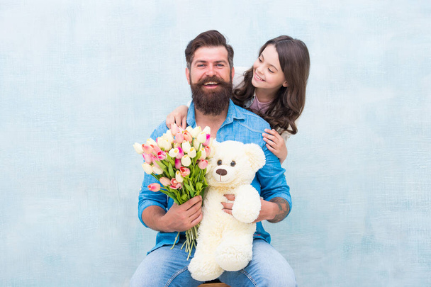 Heres to celebrating you. Happy family celebrate birthday. Little girl congratulate bearded man. Small daughter and father hold flowers and toy. Birthday anniversary. Happy birthday to you - Фото, изображение