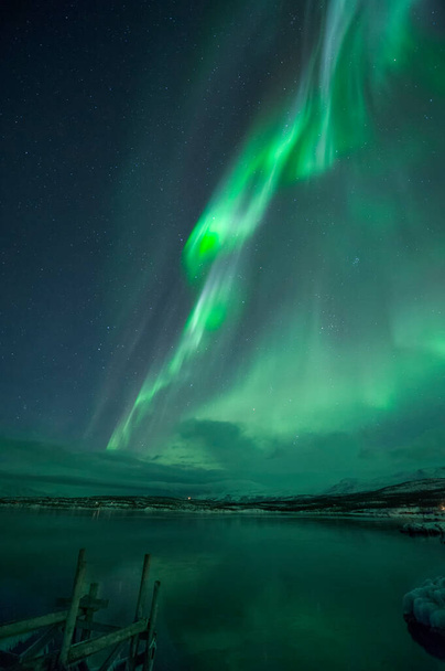 Северное сияние Aurora Borealis около Abisko и озера Торнетраск в Арктической Швеции. Высокое качество фото - Фото, изображение
