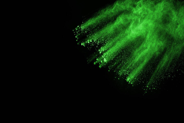 The movement of abstract dust explosion frozen green on black background. Stop the movement of powdered green on black background. Explosive powder green on black background. - Foto, immagini