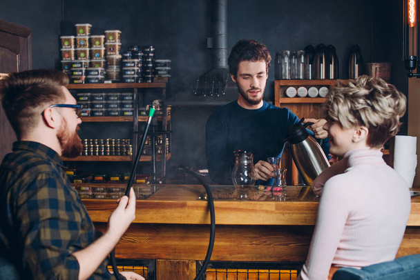 pleasant barmen offer some drink for customers - Valokuva, kuva