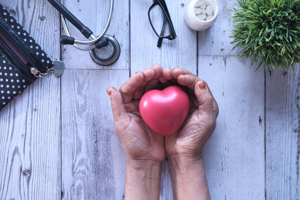 starsze kobiety trzymające czerwone serce w rękach - Zdjęcie, obraz