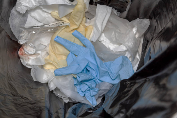 Une paire de gants Latex / Nitrile bleus usagés jetés à la poubelle - Photo, image
